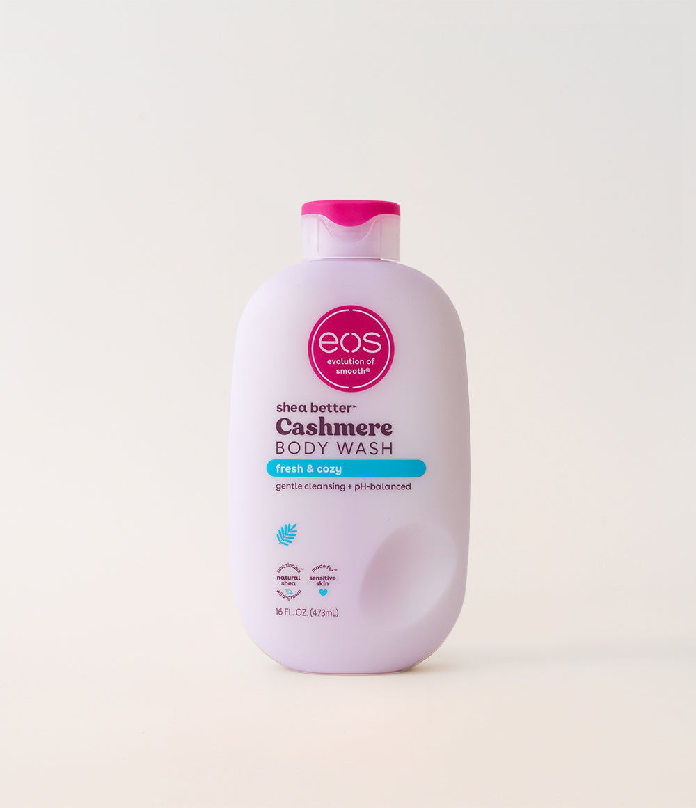 A bottle of EOS Cashmere body wash with a pink cap on a white background.